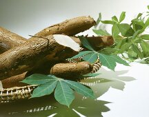 Maniok mit Blättern im Korb