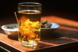 A glass of lotus tea with lotus blossom