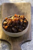 Terracotta bowl of raisins on a wooden board