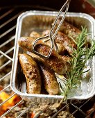 Home-made lamb sausages in aluminium dish