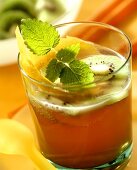 Fruit juice punch garnished with kiwi fruit, lemon peel & mint
