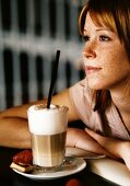 Freckled young woman with latte macchiato
