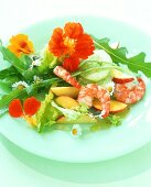 Colourful salad with apples, shrimps and edible flowers