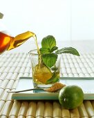 Pouring lime and mint tea into glass