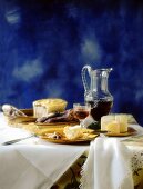 French table scene with sausage, bread, cheese, pâté, wine