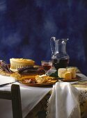 French table scene with sausage, bread, cheese, pate, wine