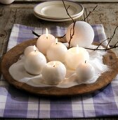 Round burning candles as winter table decoration