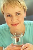 Junge sportliche Frau hält Glas Wasser