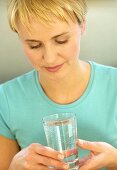 Junge sportliche Frau hält Glas Wasser