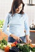 Frau schneidet Gemüse klein