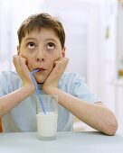 Junge trinkt Milch mit Strohhalm