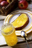 Apple & ginger jelly in jar and on a slice of bread & butter