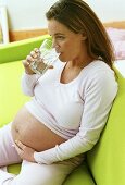 Schwangere Frau trinkt Glas Wasser