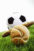 Sausage in a roll in front of a football