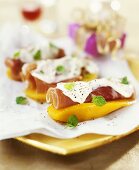 Ham rolls with sour cream on mango slices