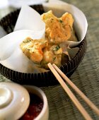 Deep-fried cauliflower on chopsticks & in bowl; dip