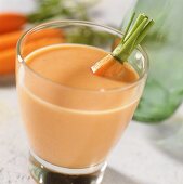 Carrot & almond flavoured milk with fresh carrot in glass