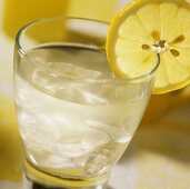 Kaltes Zitronensaftgetränk mit Zitronenscheibe am Glasrand