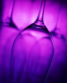 Empty wine glasses against a violet backdrop