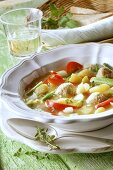 Vegetable stew & dumplings; white wine glass; bread in basket