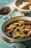 Oxtail soup with white bread and red wine glass