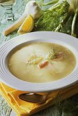 Fennel soup with salmon on white plate