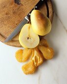 Halved fresh pear beside dried pear halves
