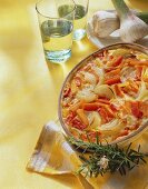 Baked ratatouille in baking dish; garlic; wine glasses