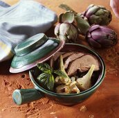 Breaded lamb's tongue with artichokes in pot