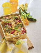 Courgette & pasta bake with tomatoes & basil in baking dish