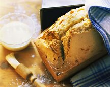 Madeira cake beside loaf tin; icing and pastry brush