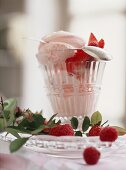 Rose ice cream with raspberries & strawberries in glass; spoon
