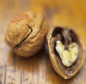 Whole and half walnut on wooden background