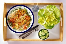 Fish with carrots, lettuce and cucumber on tray