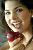 Young woman eating red apple