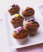 Mini-chocolate muffins with  chocolate beans in paper cases