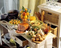 Brunch buffet with roast ham, muffins, salad and fruit