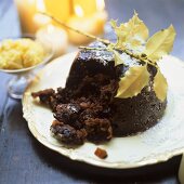 Christmas pudding, cut into; decoration: burning candles