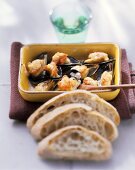 Mussel gratin, slices of bread in front