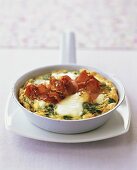 Cheese omelette with spinach and ham in frying pan