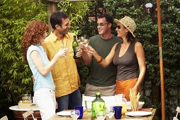 Two couples drinking white wine at barbecue