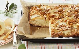 Apple butter cake with flaked almonds, partly sliced