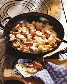 Fried potatoes with sausage, tomatoes and cheese