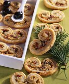 Puff pastry 'pig's ears' filled with cheese, ham and olives