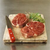 Two beef steaks on chopping board