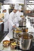Three chefs at work in a commercial kitchen