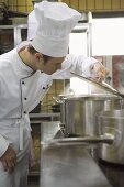 Chef examining the contents of a pan