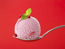A scoop of pomegranate ice cream on a spoon