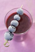 Wild berry smoothie with frozen blueberry skewer