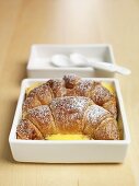 Zwei Schokoladencroissants in Vanillepudding